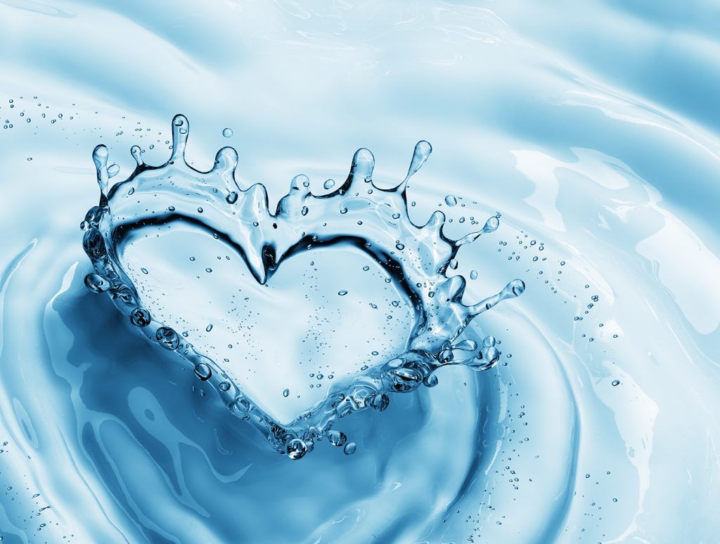 Heart from water splash with bubbles on blue water background